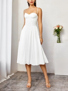 Détail du corsage style corset avec coutures structurées sur une robe midi blanche