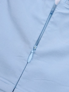 Close-up of invisible zipper detail on light blue slub fabric A-line mini dress