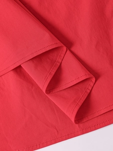 Vue macro détaillée de la texture verticale fine et de la couture de l'ourlet rouge de la robe