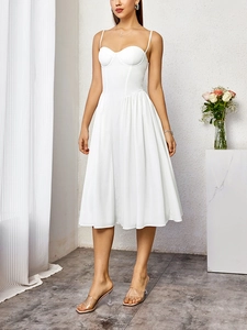 Détail de robe midi bustier blanche avec fines bretelles et jupe plissée en coupe trapèze