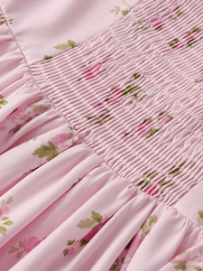 Detail of pink floral print fabric featuring elastic smocked shirring and soft texture