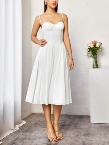 Détail d'une robe midi corset blanche avec fines bretelles et jupe évasée plissée élégante