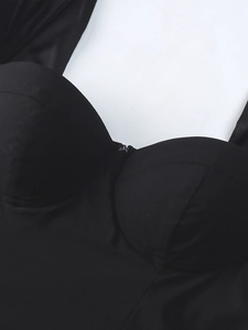 Détail de la robe trapèze noire avec bonnets de soutien-gorge structurés et texture mate chic