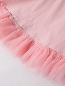 Detail shot of the pink mini dress featuring delicate mesh ruffle hem and fine stitching