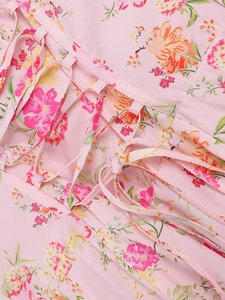 Detailed view of the criss-cross lace-up back on a pink floral print maxi dress