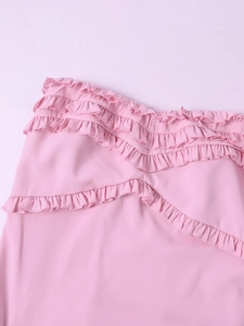 Detail of pink chiffon dress featuring tiered ruffle trim and layered frill textures