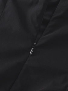 Gros plan détaillé d'une fermeture éclair invisible sur une robe noire texturée