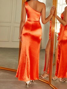 Détail de la robe longue en satin orange vif avec dos nu et coupe à une seule épaule
