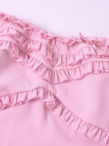 Detailed close-up of layered pink chiffon ruffles and fine stitching on a dress
