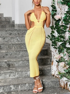 Detail of yellow crochet knit maxi dress with halter neck and side waist cut-outs