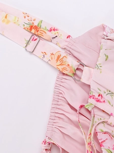 Detail of adjustable straps and silver metal buckles on a pink floral print dress