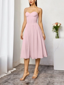Détail de robe bustier rose clair avec fines bretelles et jupe évasée à plis fins