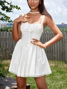 Close-up of white cottagecore dress with lace patchwork and delicate bow details