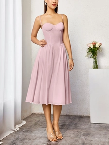 Détail du corsage style corset rose et de la jupe plissée sur une robe midi d'été