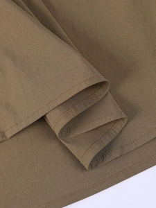 Détail de l'ourlet à double couture sur le tissu tencel texturé marron foncé