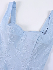 Détail de la robe jacquard bleu clair montrant la texture florale et le col carré