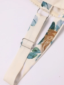 Detail of floral spaghetti strap with silver metal ring and delicate lace trim