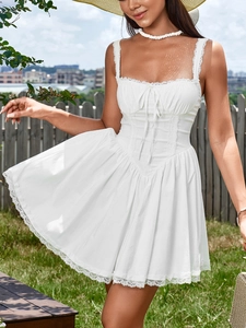 Detailed view of white mini dress featuring lace straps and corset bodice with tied waist
