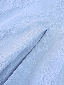 Vue détaillée du tissu jacquard bleu clair avec de délicats motifs de roses en 3D