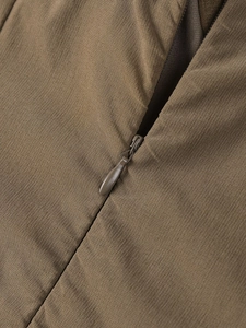 Détail d'une fermeture éclair invisible sur une robe trapèze de couleur kaki foncé