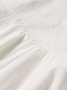 Close-up of white Tencel slub fabric with delicate texture and stitching details