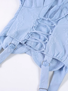 Détail de la robe jacquard bleu clair avec bretelles à lacets et détails d'anneaux métal