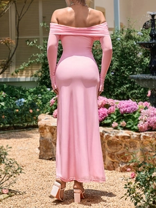 Back view of a pink off-shoulder long sleeve maxi dress with bodycon fit in a garden
