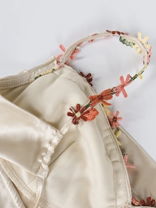 Vue détaillée de la robe en satin champagne avec broderie florale 3D colorée