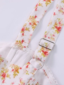 Detail of adjustable silver metal strap slider on a floral print white summer dress
