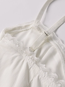 Detail of white mini dress with lace trim and adjustable thin spaghetti straps