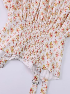 Detail of floral dress with smocking waist, silver buckle, and delicate lace trim