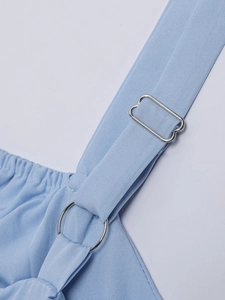 Close-up of adjustable metal buckle and ring on a light blue fabric shoulder strap