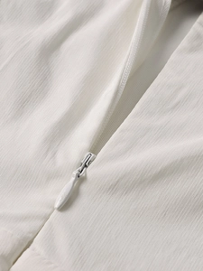 Detailed macro view of high-quality invisible zipper on a white Tencel texture dress