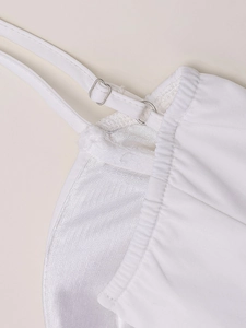 Détail d'une robe blanche avec bretelles réglables, boucles en métal et doublure en maille