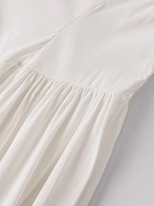 Gros plan du tissu en tencel blanc montrant la texture plissée et le détail de la taille