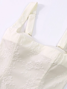 Détail de texture jacquard florale et boucle argentée sur robe à bretelles crème
