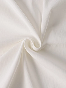Vue macro détaillée du tissu Tencel crème et du drapé plissé doux sur la robe longue