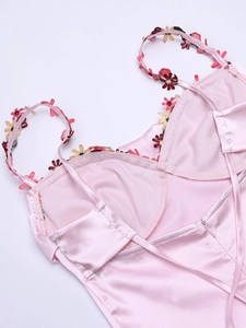 Détail du dos de la robe en satin rose avec broderie florale et fermeture éclair