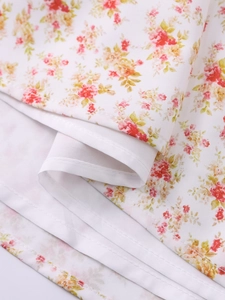 Macro detail of floral print chiffon fabric with delicate rolled hem and soft white lining
