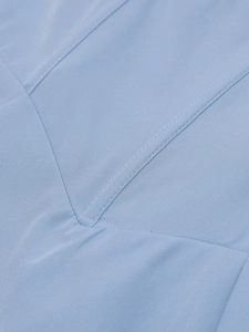 Macro detail of the V-shaped stitching on the light blue fishbone midi dress fabric