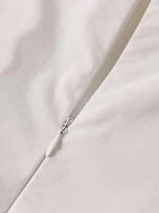 Détail de la fermeture éclair invisible et du tissu rayé sur la robe blanche