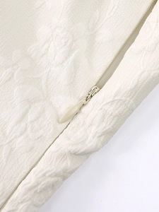 Gros plan sur la fermeture éclair invisible d'une robe jacquard beige à fleurs