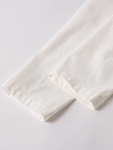 Détail des poignets blancs avec texture verticale et finitions à double couture fine