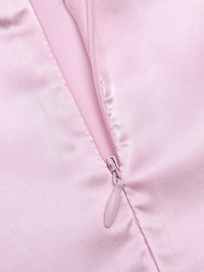 Détail du tissu en soie rose avec une fermeture éclair invisible discrète et lisse