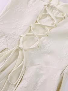 Détail du tissu jacquard crème et du laçage réglable au dos d'une robe dos nu