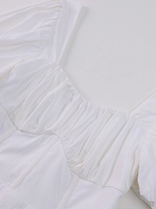 Detail view of square neckline and ruched bustier design on white mesh dress