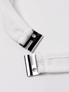 Détail de la boucle argentée et des bretelles blanches sur un haut dos nu sexy