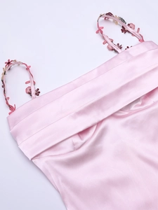 Détail de robe en satin rose avec décolleté plissé et broderies florales fines