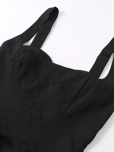 Gros plan sur tissu jacquard noir avec broderie florale et bretelles réglables de robe