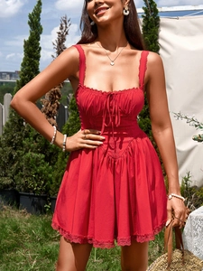 Close-up of red A-line dress featuring lace patchwork details and a V-shaped waistline